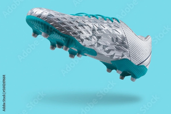 Obraz Silver football shoes with a turquoise sole, levitate on a turquoise background, concept