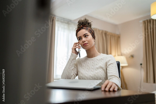 Obraz one woman sit in bedroom or hotel room use mobile phone make a call