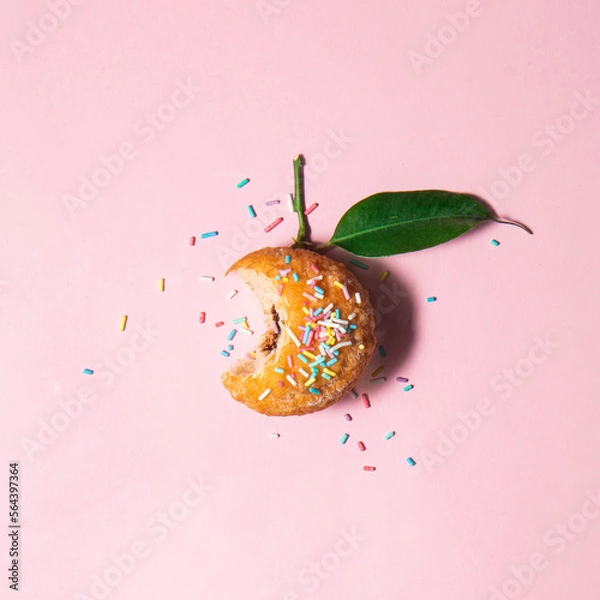 Fototapeta Healthy or tasty food concept. Doughnut and sprinkles on pastel light pink background. Minimalistic fruit composition.