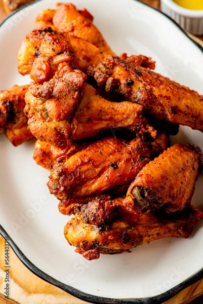 Fototapeta 
Chicken wings. Buffalo chicken wings. American cuisine of chicken wings deep-fried, dipped in buffalo sauce made of vinegar,  cayenne hot sauce and butter. Served with celery, carrots, blue cheese.