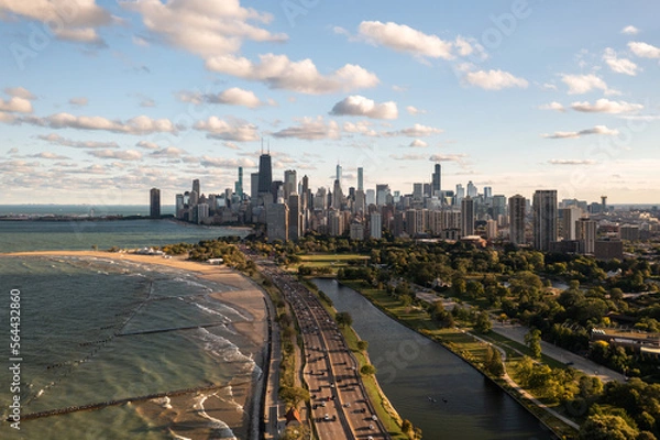 Fototapeta Downtown Chicago city skyline aerial centered over traffic along Lake Shore Drive between South Lagoon and Lake Michigan on a sunny day with fluffy white clouds in a blue sky above.