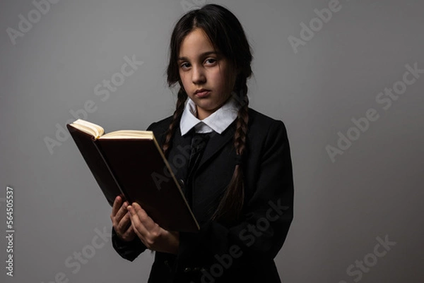 Fototapeta A girl with braids in a gothic style on a dark background.