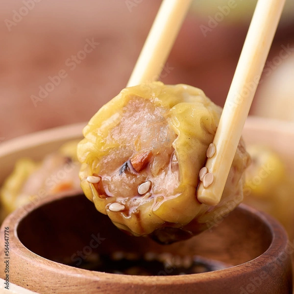 Fototapeta Entering a dim sum in sauce with chopsticks