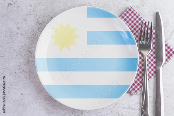 Fototapeta A Plate with the Flag of Uruguay, Cutlery and Napkins on the Mable Table.