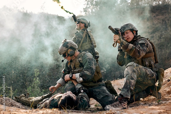 Fototapeta Rapid reaction special forces, soldiers in combat wear in action, covering each other, protecting injured comrade lying on ground. friendly team of caucasian european military people on war