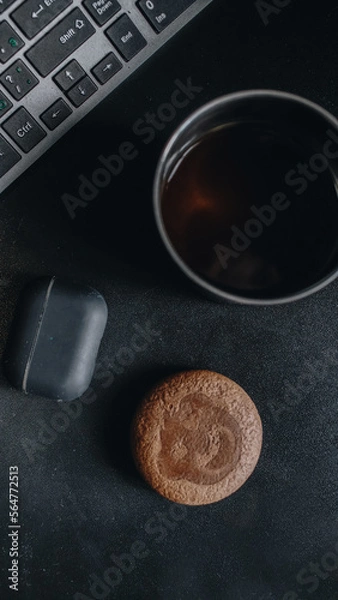 Fototapeta Morning coffee and cookies by the computer keyboard and headphones