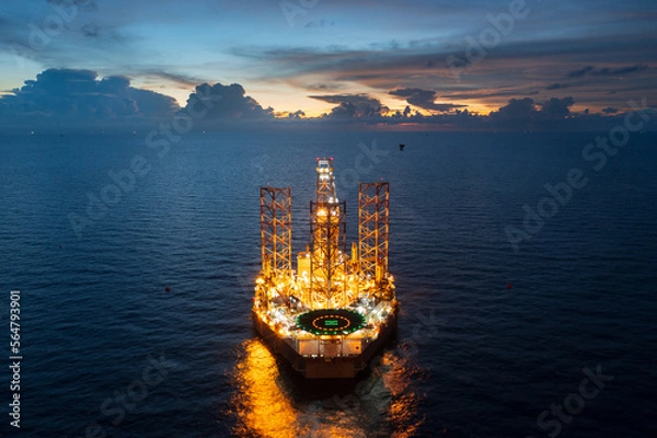 Fototapeta Aerial view of jack up drilling rig in the middle of the ocean while rig move at night time