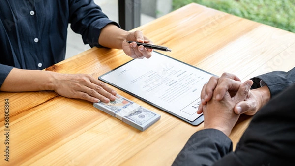 Fototapeta Bribe employer is handing over a pen and offer terms to businessman for signing on contract while making corruption about buy land and real estate