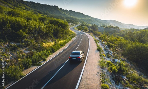Fototapeta Driving on a coast road. Aerial view of a car driven on an amazing curved waving road at the Sea shore in Balchik sea resort in Bulgaria.