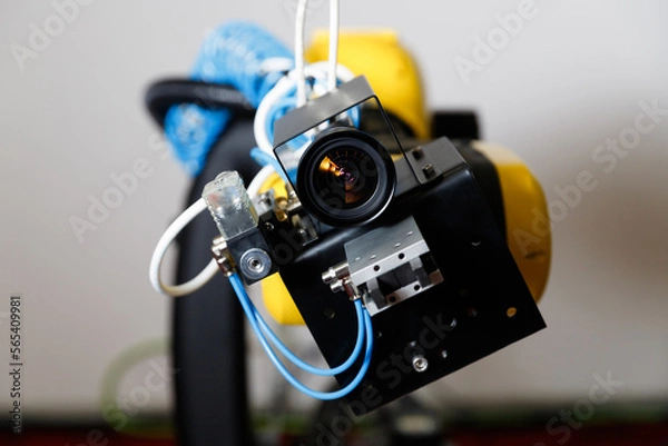Fototapeta machine vision. The robot is staring at the viewer. The manipulator arm uses a camera to observe and control objects.