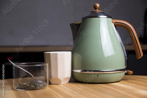 Fototapeta stylish teapot, cup and green tea with teaspoon stand on wooden table in kitchen