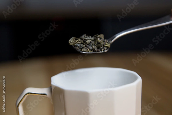 Fototapeta adding green tea to the cup