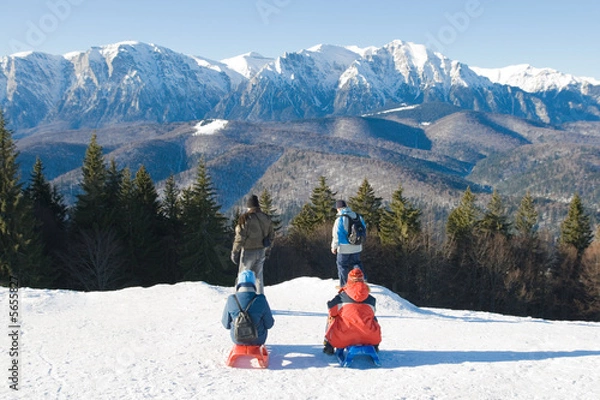 Fototapeta Four people enjoying the fresh air at the mountain. Back view. Winter landscape.