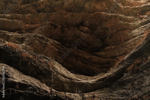 Fototapeta Bizarre shapes in a dark mountain gorge - with layers illuminated by the sun.