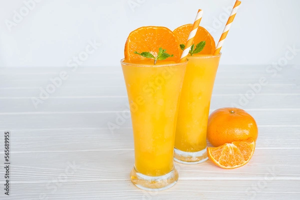 Fototapeta Orange smoothies yellow colorful fruit juice milkshake blend beverage healthy high protein the taste yummy In glass,drink to lose weight drink episode morning on white gray background.