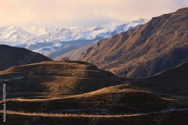 Fototapeta Picturesque mountain landscapes of Dagestan - with ancient terraces and peach trees - and a blue sky with clouds on a sunny winter day.