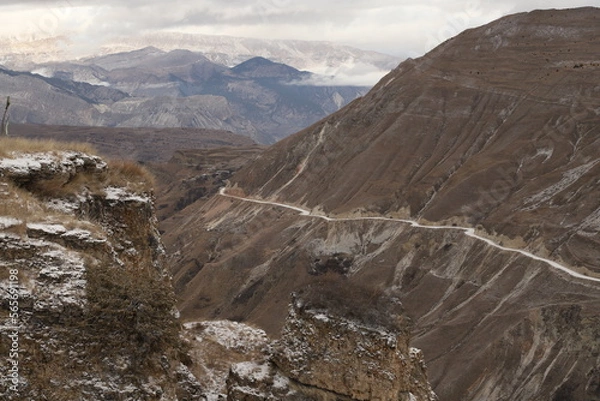 Fototapeta Scenic panorama: foggy mountains, cloudy sky and undulating slopes on a winter day in Dagestan.