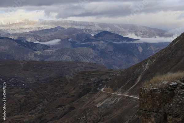 Fototapeta Scenic panorama: foggy mountains, cloudy sky and undulating slopes on a winter day in Dagestan.