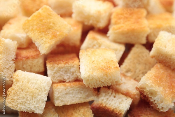 Fototapeta Delicious crispy croutons as background, closeup view