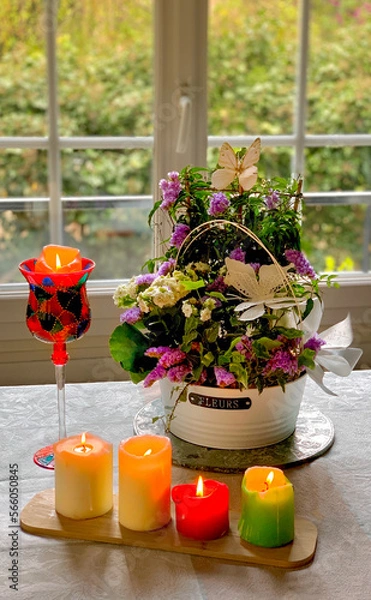 Fototapeta Composition florale avec Jolies fleurs dans un pot et avec des bougies allumées 
