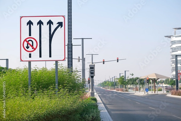 Fototapeta Large board of a series of road signs on an empty highway, no U-turn, highway exit