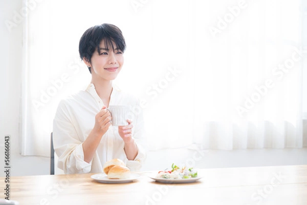 Fototapeta コーヒーを飲んでゆったりくつろぐ女性　コピースペースあり