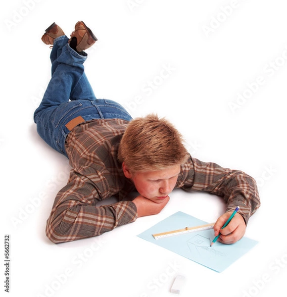 Fototapeta Blond boy drawing a pencil picture lying on the floor