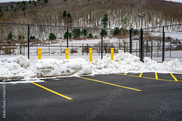 Obraz 4 Large Yellow Concrete Pillars are placed on the edge of the parking lot to protect the Tennis Court fences from being damaged during snow plowing in the winter in Upstate NY.