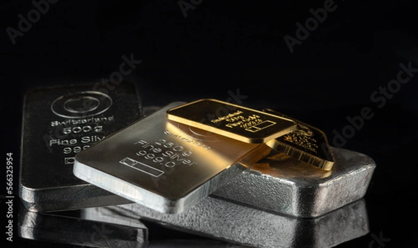 Fototapeta Gold and silver bars of various weights on a dark background. Selective focus.
