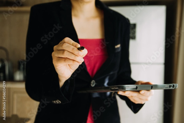 Fototapeta Mature businessman using a digital tablet to discuss information with a younger colleague in a modern business lounge