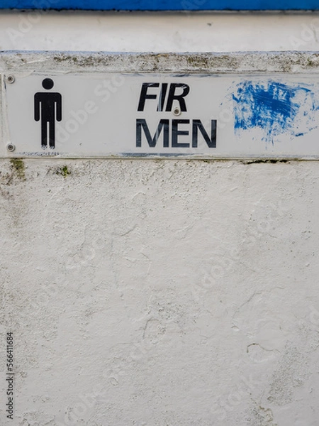 Fototapeta Sign men in Irish and English language on a changing room by a beach or toilet. Multi language culture concept. White wall with texture.