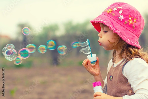 Obraz Little girl playing with soap bubbles