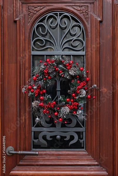 Fototapeta Beautiful Christmas wreath hanging on wooden door