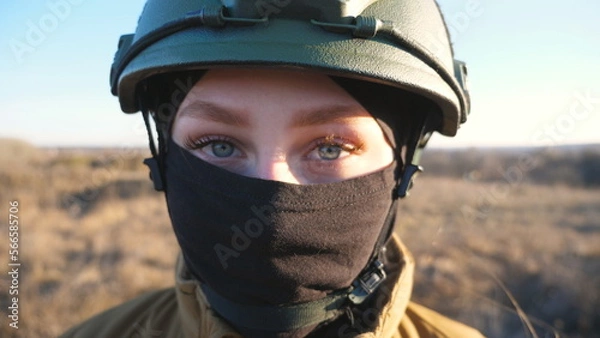Obraz Sight of female ukrainian army soldier in helmet. Portrait of young woman in camouflage uniform confidently looking at camera. Military forces during war. Russian invasion of Ukraine. Close up