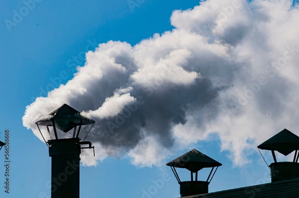 Fototapeta A View of White Smoke Coming out of a Chimney in an Engine Shed on a Sunny Day
