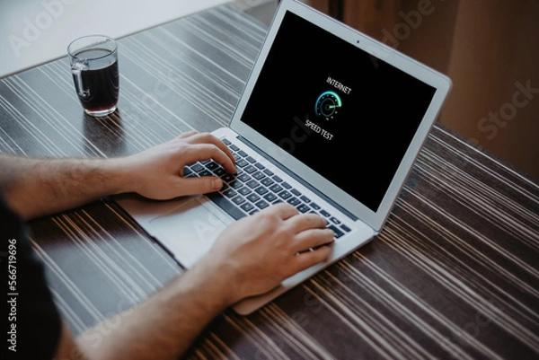 Fototapeta Man checking internet connection speed on laptop