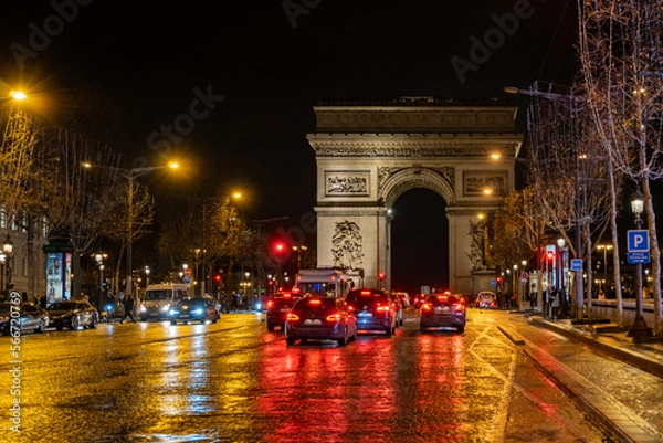 Fototapeta A nighttime view looking up the Champs-Élysées towards The Arc de Triomphe, a famous landmark in Paris, France. 