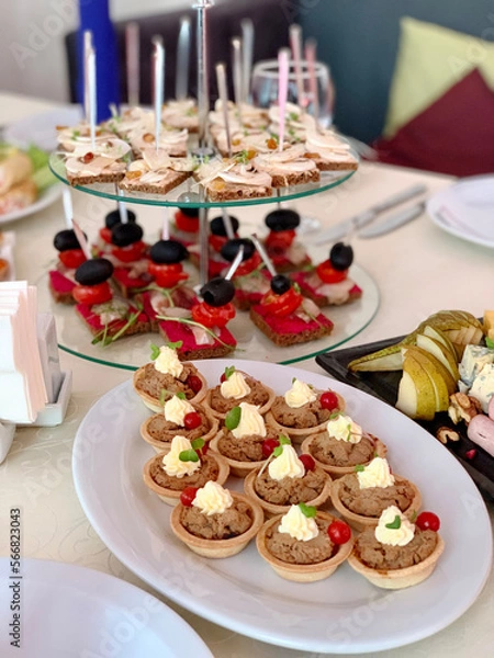 Fototapeta table setting with appetizers, plates, glasses