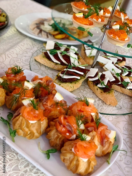 Fototapeta table setting with appetizers, plates, glasses