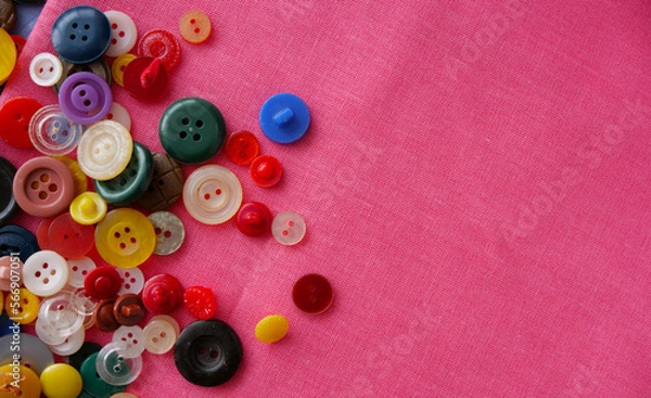 Fototapeta multi-colored buttons on red fabric. Place for an inscription