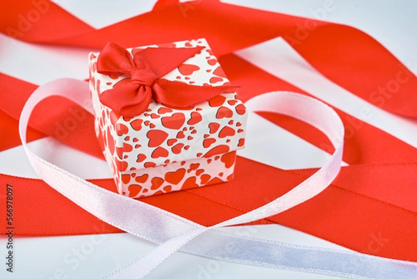 Fototapeta Background image of red and white ribbons and a small gift box with a rat bow.