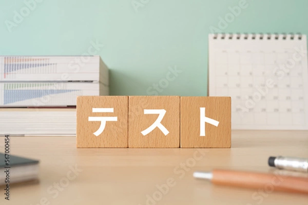 Fototapeta テストと書かれたブロックが置かれたデスク