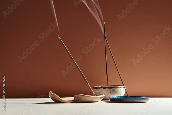 Fototapeta A set of burning incense for yoga or meditation. Minimalistic concept with warm colors