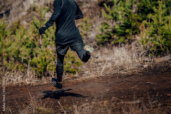 Obraz male runner run down mountain in muddy trail