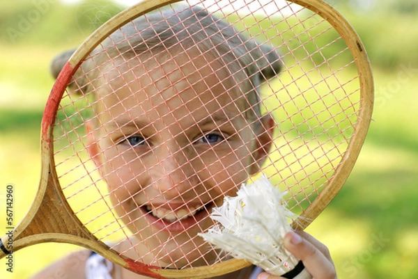 Obraz European girl with blue eyes with a badminton racket smiling. Active rest in summer. Summer vacation concept