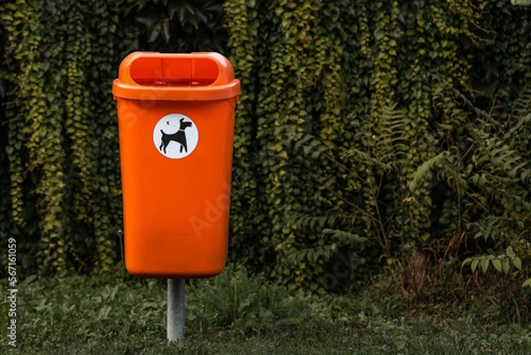 Fototapeta orange trash can basket, Dispose dog waste in a trash can.
Responsibility for people around the environment.