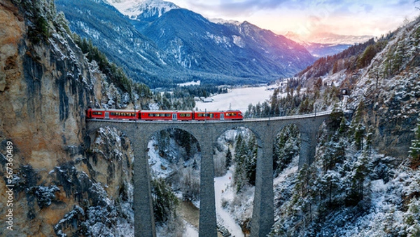 Fototapeta Aerial view of Train passing through famous mountain in Filisur, Switzerland. Landwasser Viaduct world heritage with train express in Swiss Alps snow winter scenery.