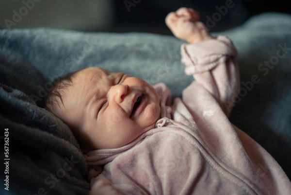 Fototapeta Weinendes Baby auf einer grauen Felldecke