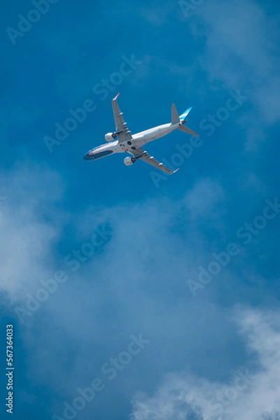 Obraz Airline plane over light blue sky with few clouds.
Plane view in full takeoff.