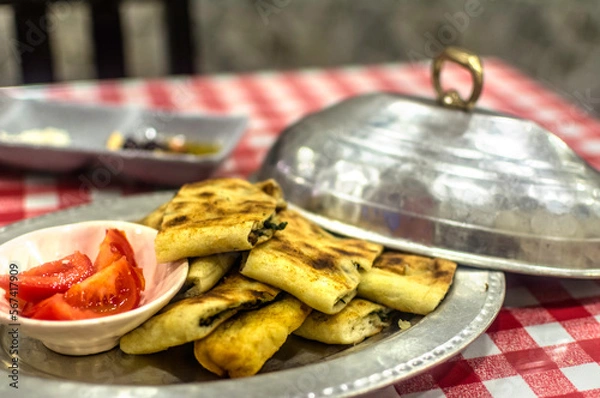 Obraz  Recipe of spinach pita and meat dish. Traditional meal from Safranbolu, Turkey, served on a platter in a restaurant.  Oriental ottoman cuisine. 
